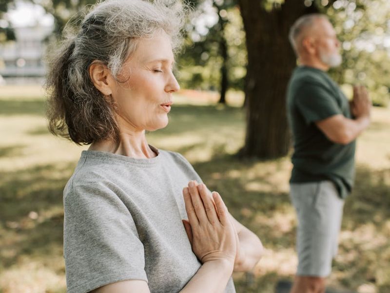 Person meditating peacefully in a serene natural environment.